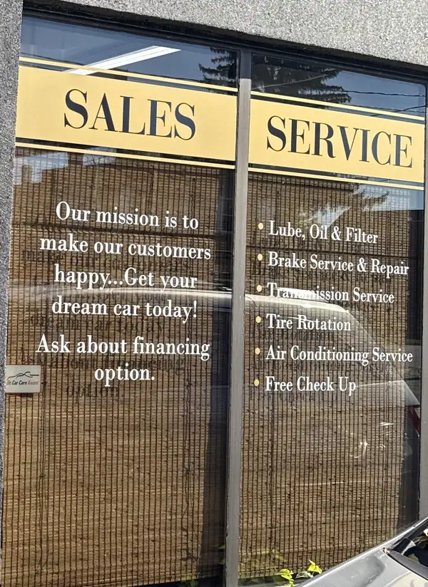 JK Motors window sign listing sales and service